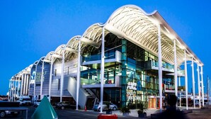 Un edificio moderno con un techo curvo distintivo y varios niveles, presumiblemente utilizado como espacio público o comercial.