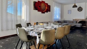 Un comedor con una mesa preparada para cuatro personas, un sofá y una chimenea.