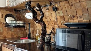 A kitchen with a wooden countertop, a sink, a microwave, and a decorative sculpture.