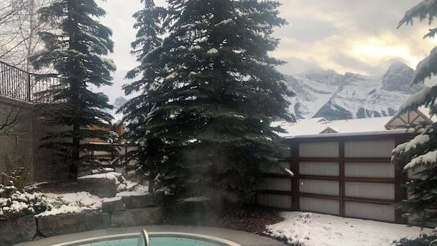 Un espace piscine offrant une vue sur des montagnes enneigées.