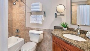 Un baño con bañera, inodoro, lavabo y espejo.