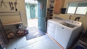 Un cuarto de lavandería con lavadora, secadora y extintor.
