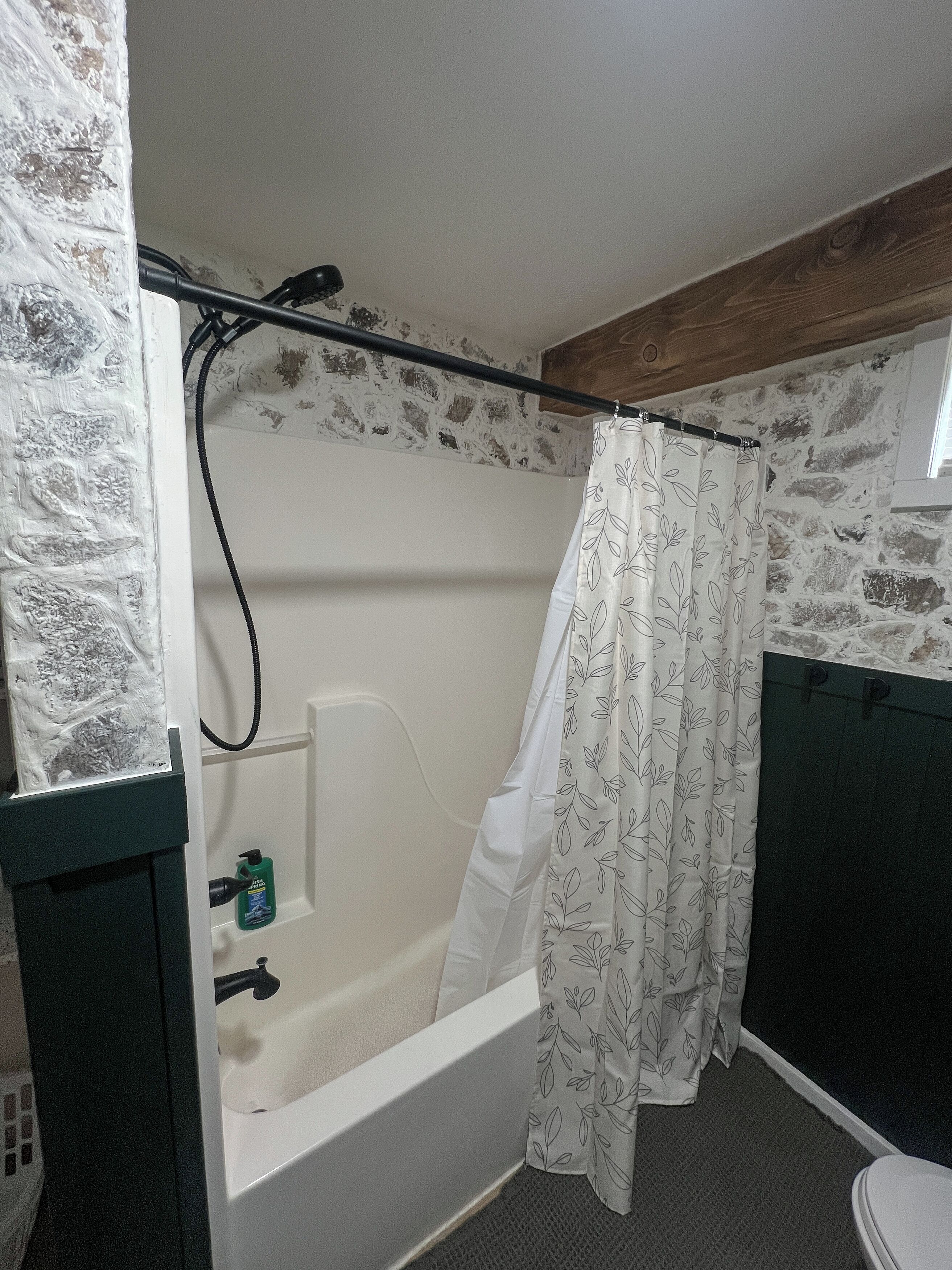 Une salle de bain avec une baignoire, un rideau de douche, des toilettes et un lavabo.