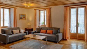 A cozy living room with two sofas, a coffee table, and a painting on the wall. - Casa Zanetti a Le Prese Appartamento "Bernina" by Interhome (Le Prese)