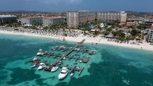 Ein Luftbild eines Küstenresorts mit einer Marina, Strand und Hochhäusern.