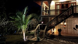 Ein zweistöckiges Haus mit Balkon, Treppe und einer gut beleuchteten Eingangsparte.