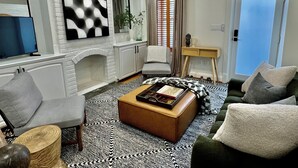 Un salon avec une cheminée, un téléviseur et un canapé.