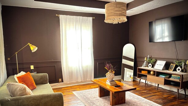 Ein Wohnzimmer mit einer Couch, einem Couchtisch und einem Fernseher.
