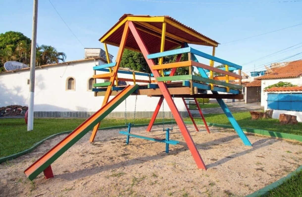 Estructura de juegos colorida con tobogán y elementos para escalar.