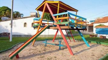 Estructura de juegos colorida con tobogán y elementos para escalar.