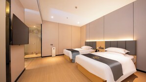 Habitación de hotel con dos camas, un televisor de pantalla plana, cabina de ducha de vidrio y diseño moderno.