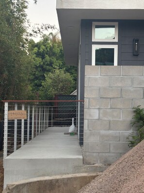 A concrete staircase leading to a building with a metal railing and a sign. - New build 2-bedroom house in Del Mar next to Torrey Pines Preserve and Beach (Del Mar)
