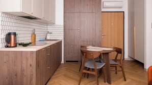 Eine moderne Küche mit Holzschränken, einer Rückwand aus Fischgrätmuster-Fliesen und einer zentralen Kochinsel mit Sitzgelegenheiten.