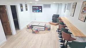 Una sala de estar moderna con televisión, asientos y chimenea.