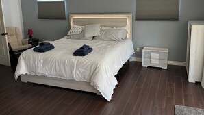 A bedroom with a bed, nightstands, a chair, a lamp, and a ceiling fan. - Peaceful Covina Stay Close to LA, Disney/Work & Adventure (Covina)