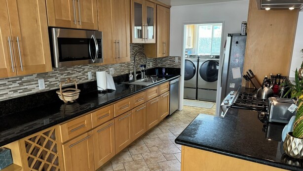 A modern kitchen with wooden cabinets, a stainless steel refrigerator, a built-in oven, a microwave, a sink, and a stove. - Peaceful Covina Stay Close to LA, Disney/Work & Adventure (Covina)