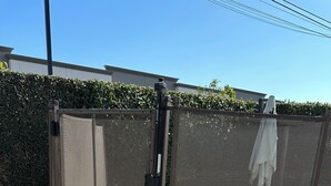 A pool area with a covered section, a tiled deck, and a hedge in the background. - Peaceful Covina Stay Close to LA, Disney/Work & Adventure (Covina)