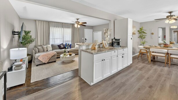 Una sala de estar moderna con un sofá, una mesa de centro y un comedor con una isla de cocina.