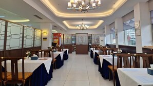 A restaurant with a long table layout, a chandelier, and framed artwork on the walls. - Shenzhen Airport Hotel Bao'an Airport  (Shenzhen)
