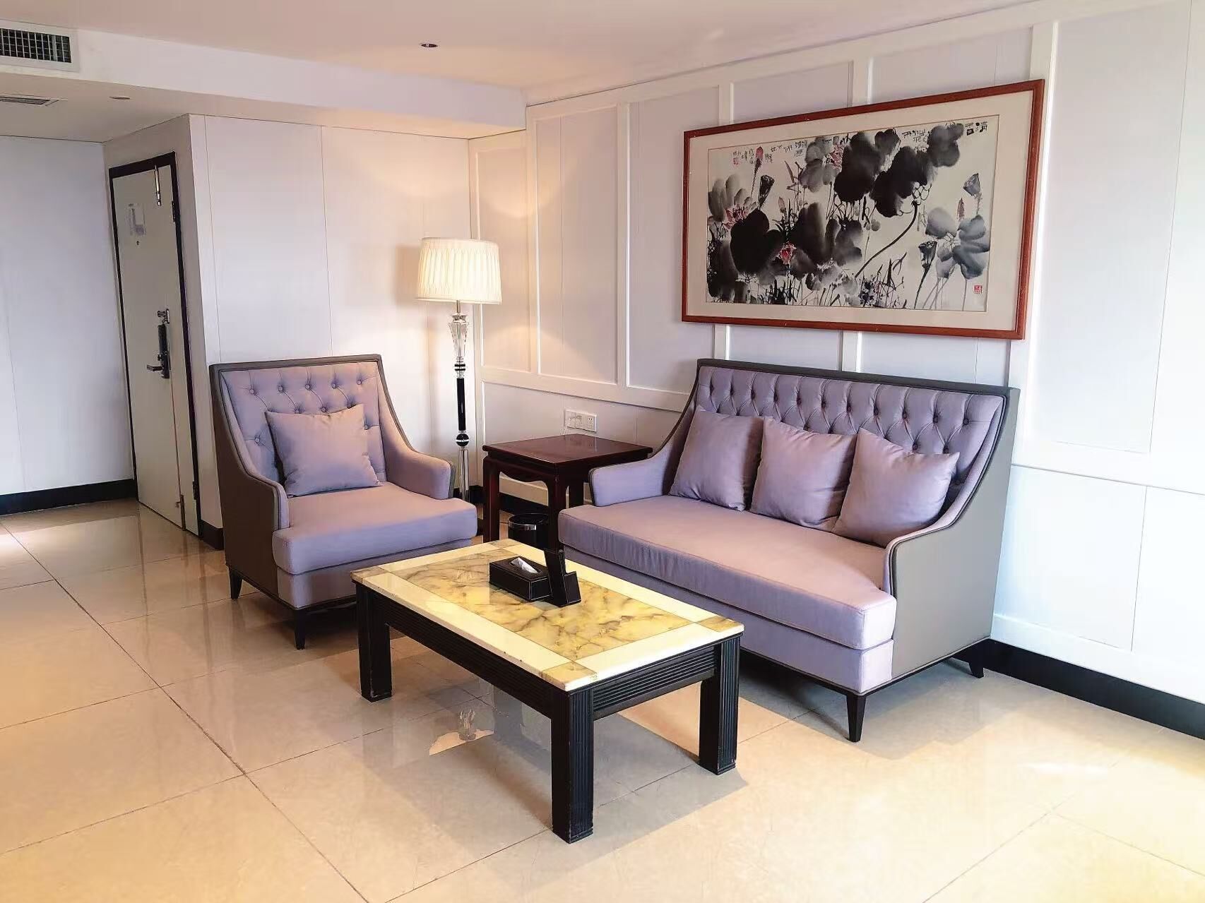 Una sala de estar moderna con un sofá, sillones y una mesa de centro.