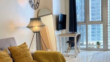 Uma sala de estar moderna com um sofá, um abajur e uma televisão.