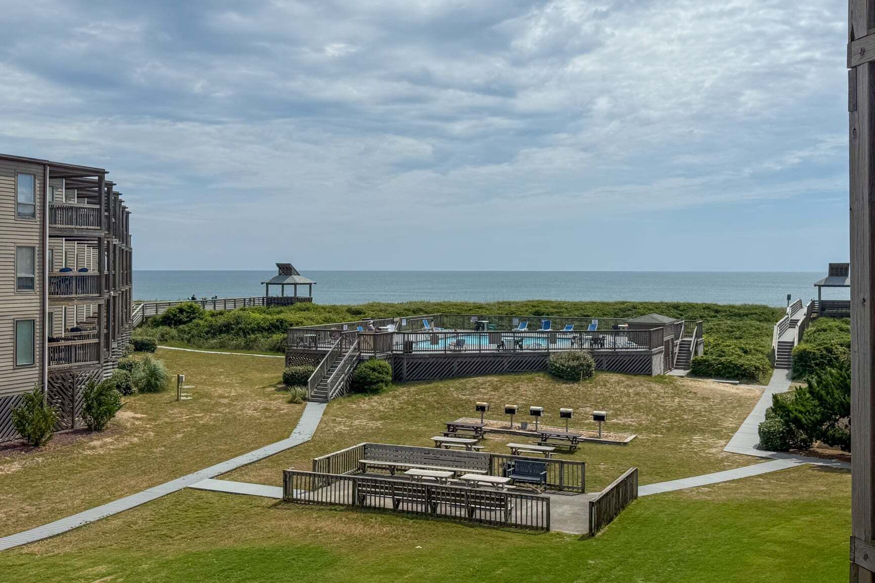 En ejendom ved stranden med en pool, udendørs siddepladser og havudsigt.