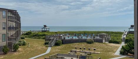 En ejendom ved stranden med en pool, udendørs siddepladser og havudsigt.