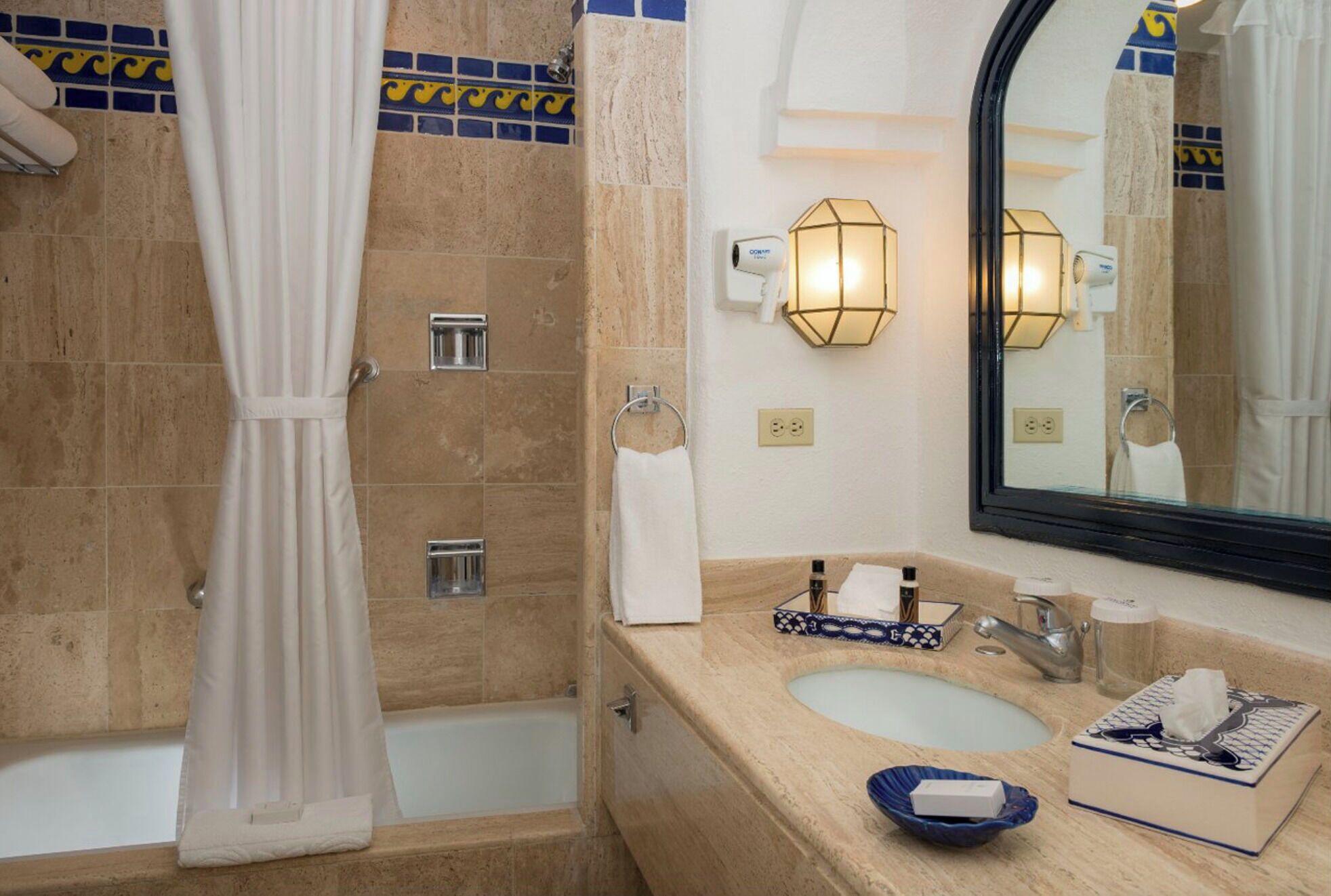 Ein Badezimmer mit einer Badewanne, einer Dusche, einem Waschbecken, einem Spiegel und einem Handtuchhalter.
