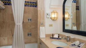 Une salle de bain équipée d’une baignoire, d’une douche, d’un lavabo, d’un miroir et d’un porte-serviettes.