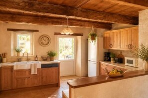 A kitchen with wooden cabinets, a sink, a refrigerator, and a microwave.