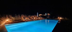 A nighttime swimming pool with lounge chairs and lights. - Farmhouse in the heart of nature, panoramic view, absolute peace and quiet. (Sault)