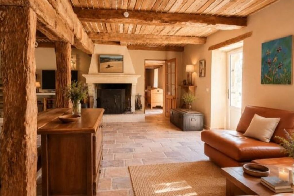 Un intérieur rustique avec une cheminée en pierre, des meubles en bois et un canapé en cuir.