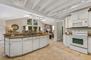 A kitchen with white cabinetry, a granite countertop, a double oven, and a large island with a sink. - Pet Friendly North Forest Beach 5BR w/ Heated Pool & Fire Pit, Walk to Beach (Hilton Head Island)
