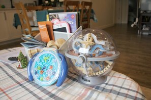 A table with a checkered tablecloth, a globe, and a toy train set. - 3BR Walk-out Retreat-Quiet Country Hills Location (Calgary)