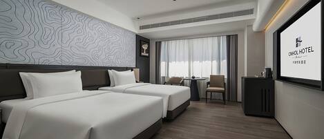 A hotel room with two beds, a desk, a chair, and a large window with curtains.