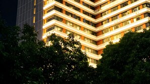 Un hôtel de grande hauteur, avec de nombreux étages, de grandes fenêtres et une enseigne bien visible au sommet.