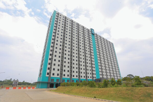 A high-rise building with a modern architectural design, featuring a prominent teal and white color scheme. - Riverdale Cikarang by ARBA (Cikarang)
