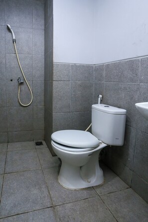 Un bagno con il water, una doccia e un lavandino.