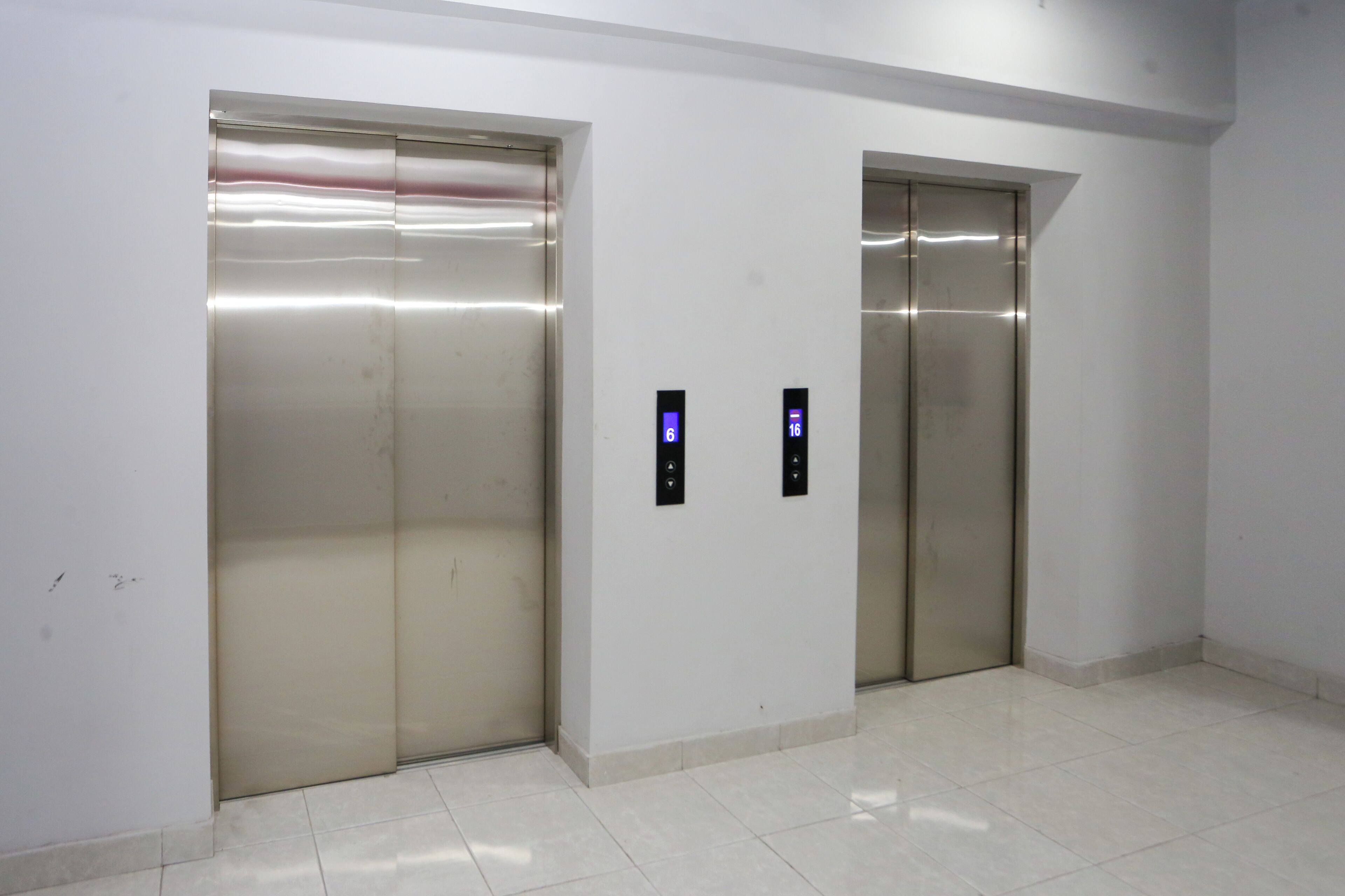 Dos ascensores con pantallas digitales que indican los pisos 6 y 16.
