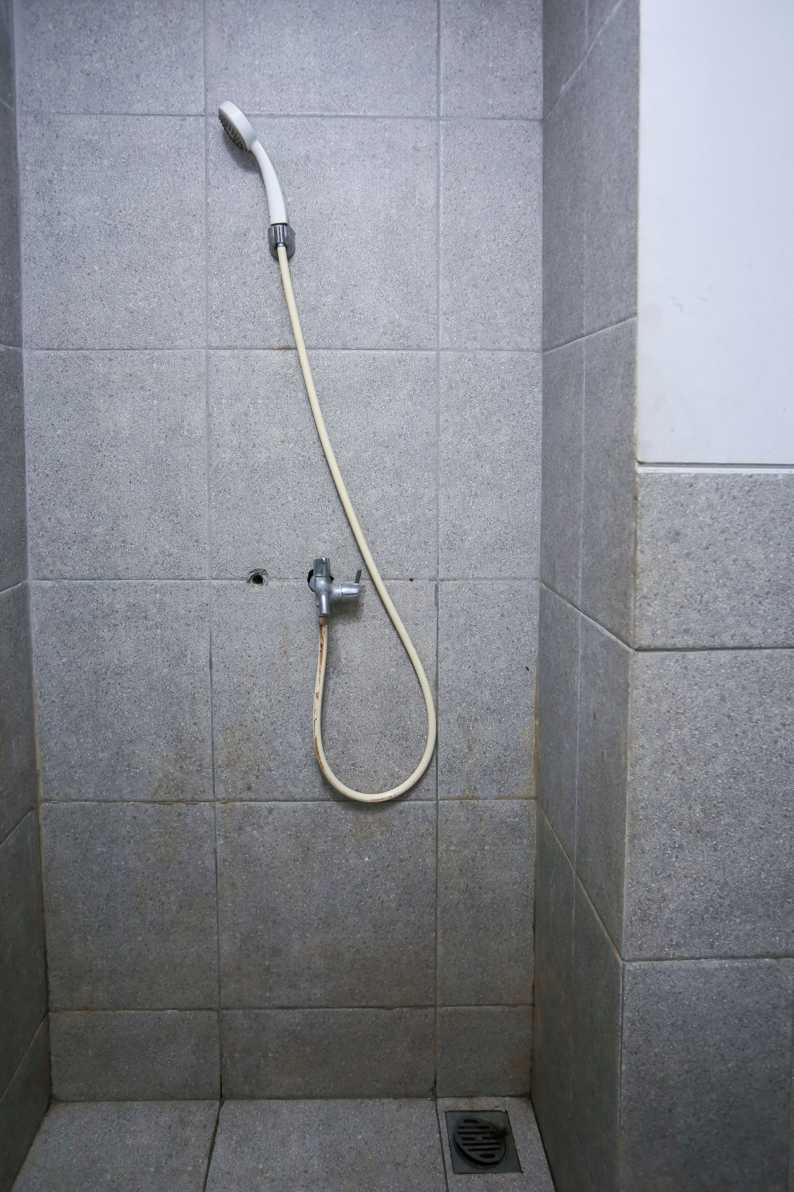 A shower with a handheld showerhead and a flexible hose.