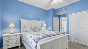 A bedroom with a bed, nightstands, and a ceiling fan. - Welcome to Oceanwalk 15-505! (New Smyrna Beach)