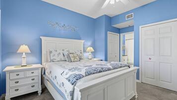 A bedroom with a bed, nightstands, and a ceiling fan.