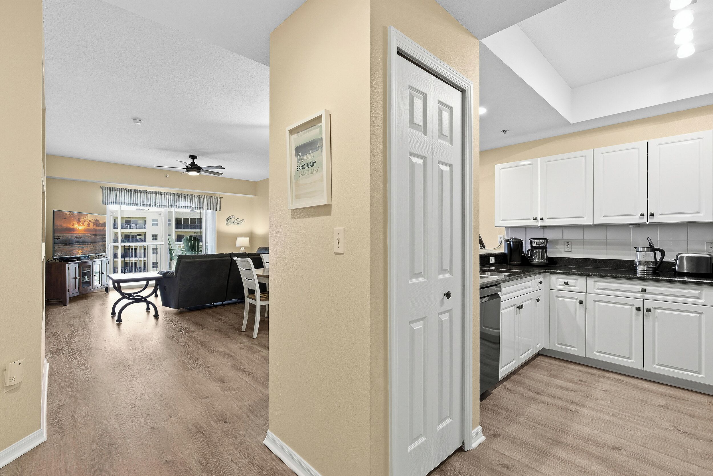 A modern kitchen with white cabinets and a dining area with a table and chairs.