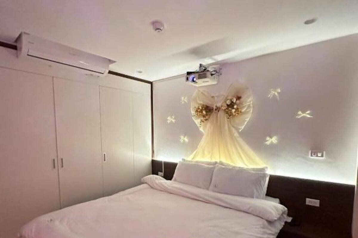 Dormitorio con cama, armario y proyector de pared.