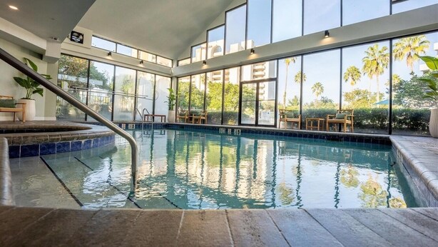 A swimming pool with a view of palm trees and a building in the background.