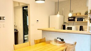 Eine moderne Küche mit einem Holzespeisetisch und Stühlen, einer Mikrowelle und einem Kühlschrank.