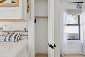 Ett sovrum med en säng, en garderob och ett fönster med utsikt över omgivningen.