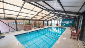 Una piscina interior con agua cristalina, carriles delimitados y señalización de seguridad.