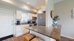 A modern kitchen with white cabinets, granite countertops, and stainless steel appliances. - Shared Pools, Boardwalk to the Beach, Golf Cart Access (Port Aransas)