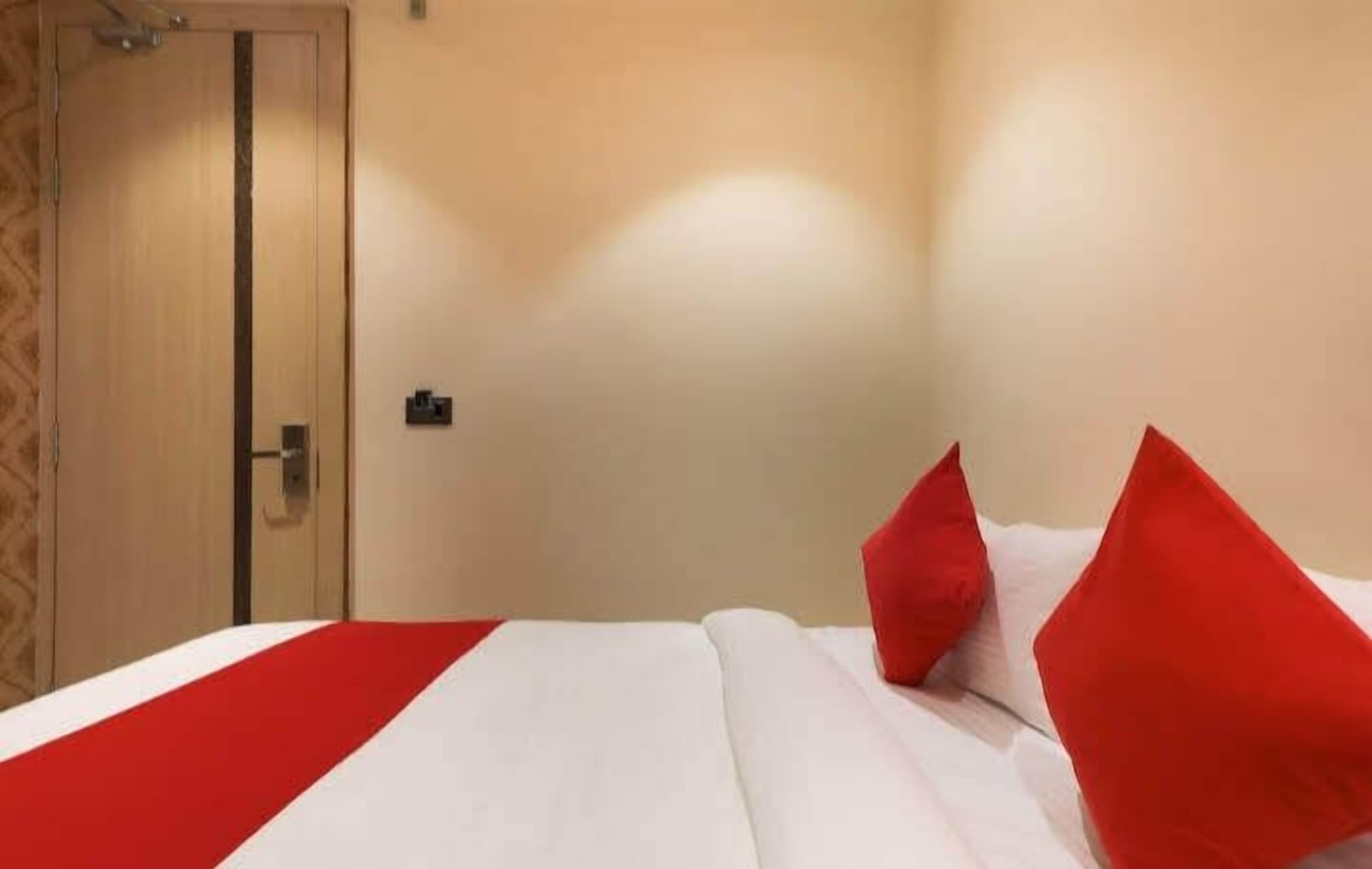 Una camera d'albergo con un letto, un armadio in legno e un lampadario a parete.